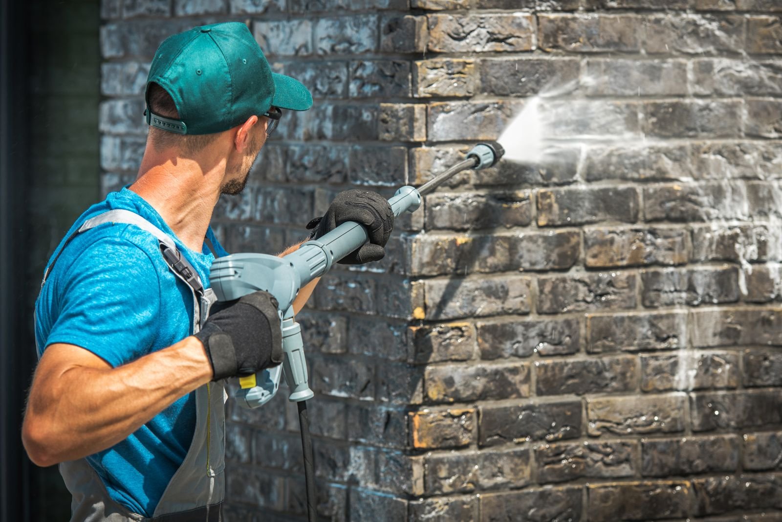 Brick wall being pressure washed clean